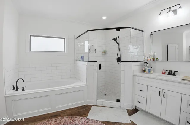 a bathroom with a bathtub a shower a sink and mirror