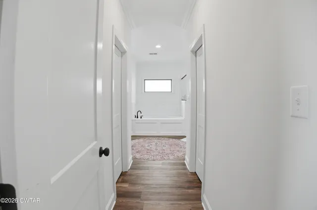 a view of a hallway with wooden floor