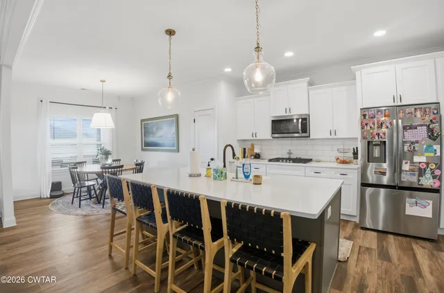 a large kitchen with kitchen island a dining table and chairs