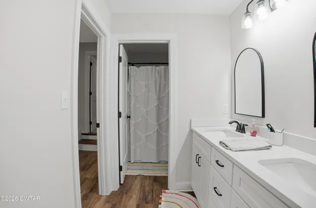 a bathroom with a double vanity sink and mirror