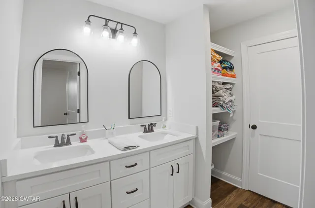 a bathroom with a double vanity sink and a mirror