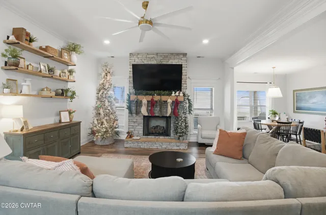 a living room with furniture a flat screen tv and a fireplace