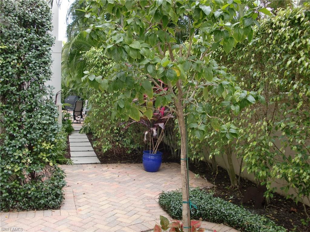 435 3rd Avenue South, Unit 3 Naples, FL 34102 - Photo 12 of 12 a front view of a house with a yard and potted plants