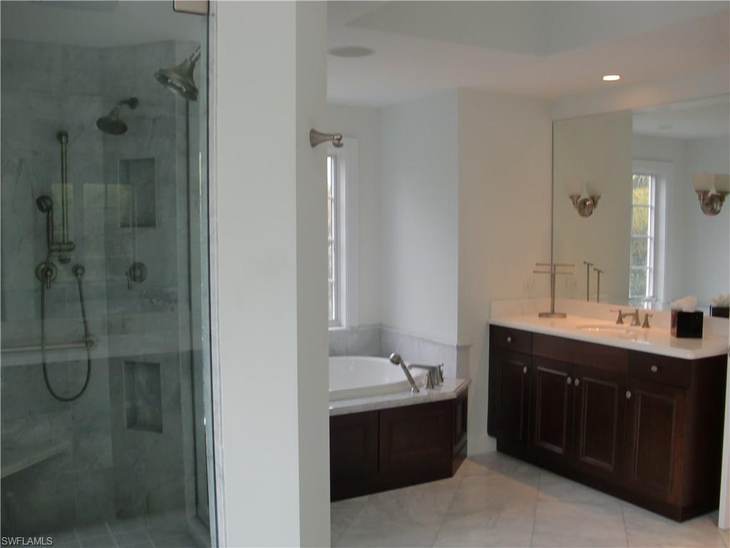 435 3rd Avenue South, Unit 3 Naples, FL 34102 - Photo 9 of 12 a bathroom with a double vanity sink mirror and shower