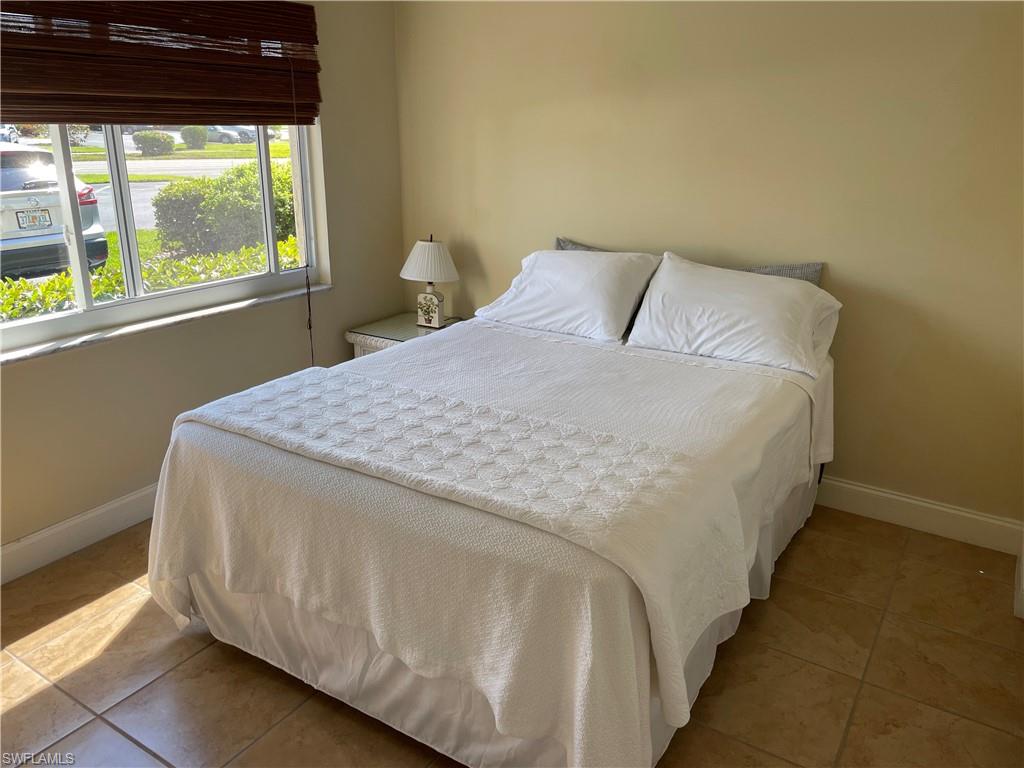 200 Palm Drive, Unit 7 Naples, FL 34112 - Photo 11 of 21 a bed sitting in a bedroom next to a window
