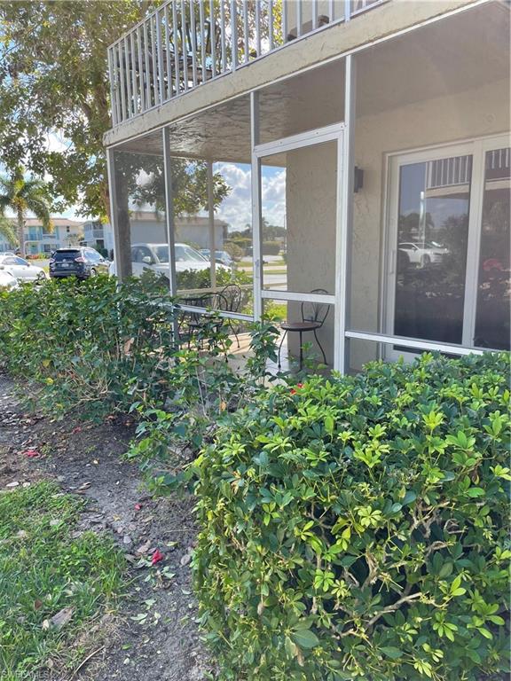 200 Palm Drive, Unit 7 Naples, FL 34112 - Photo 20 of 21 a view of a house with a small yard and a large tree