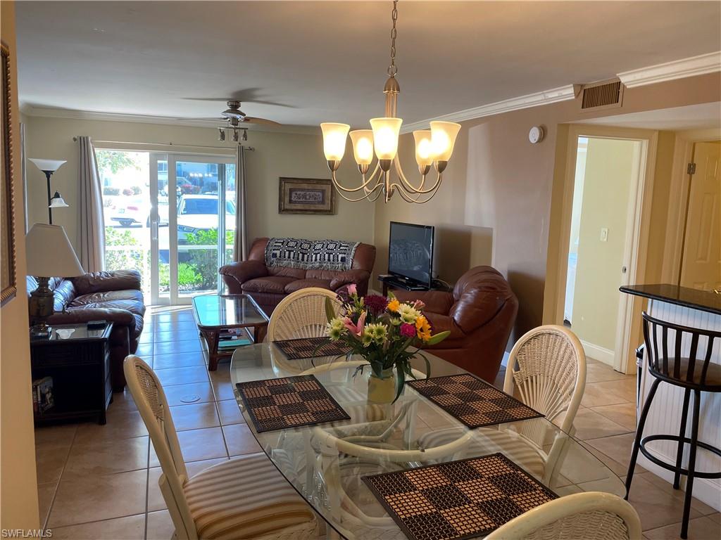 200 Palm Drive, Unit 7 Naples, FL 34112 - Photo 2 of 21 a living room with furniture chandelier and a window