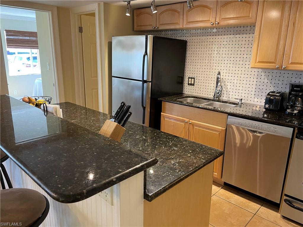 200 Palm Drive, Unit 7 Naples, FL 34112 - Photo 3 of 21 a kitchen with a sink a refrigerator and cabinets