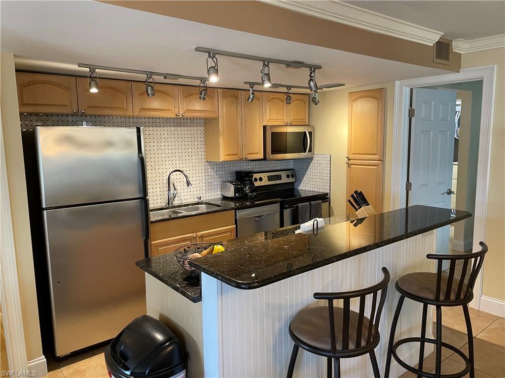 200 Palm Drive, Unit 7 Naples, FL 34112 - Photo 4 of 21 a kitchen with stainless steel appliances granite countertop a refrigerator a sink and a stove