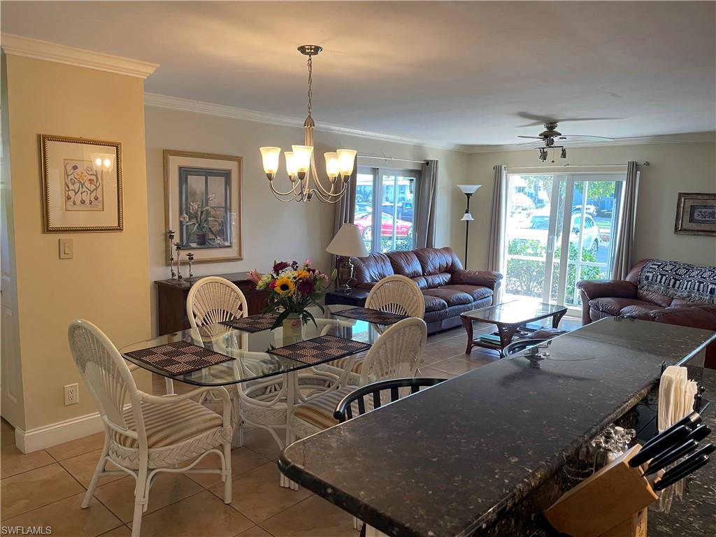 200 Palm Drive, Unit 7 Naples, FL 34112 - Photo 5 of 21 a living room with furniture a chandelier and a table