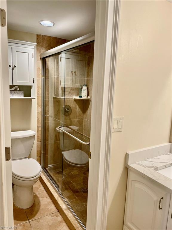 200 Palm Drive, Unit 7 Naples, FL 34112 - Photo 8 of 21 a bathroom with a granite countertop toilet and a shower