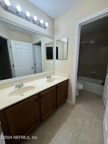 a bathroom with a sink double vanity granite and a mirror