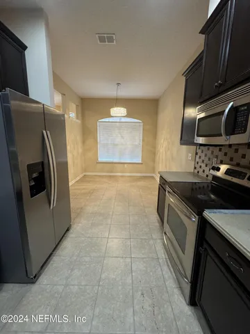 a kitchen with granite countertop a stove and a refrigerator