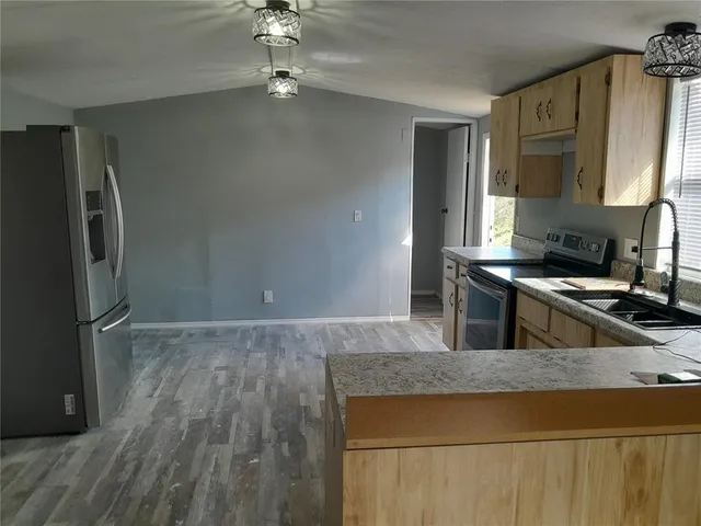 a kitchen with kitchen island a counter top space appliances and cabinets