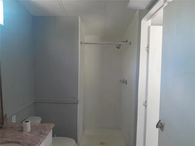 a bathroom with a granite countertop sink and toilet