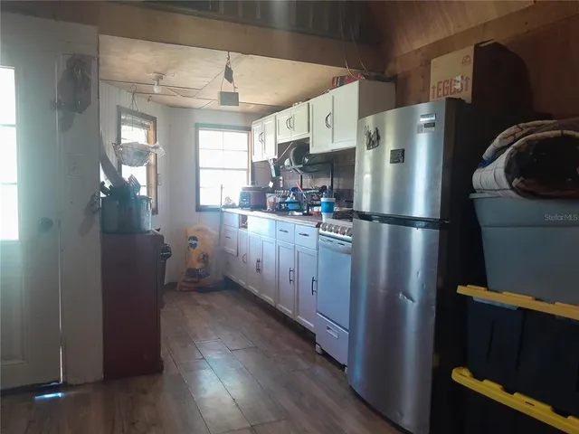 a kitchen with refrigerator cabinets and wooden floor