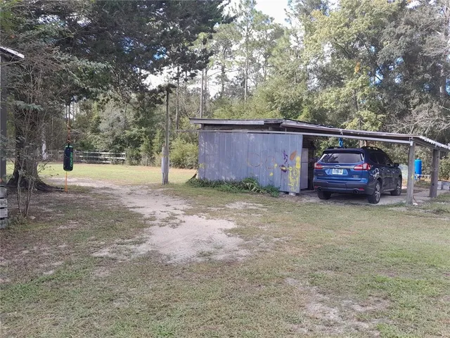 a backyard of a house with barbeque oven and wooden fence