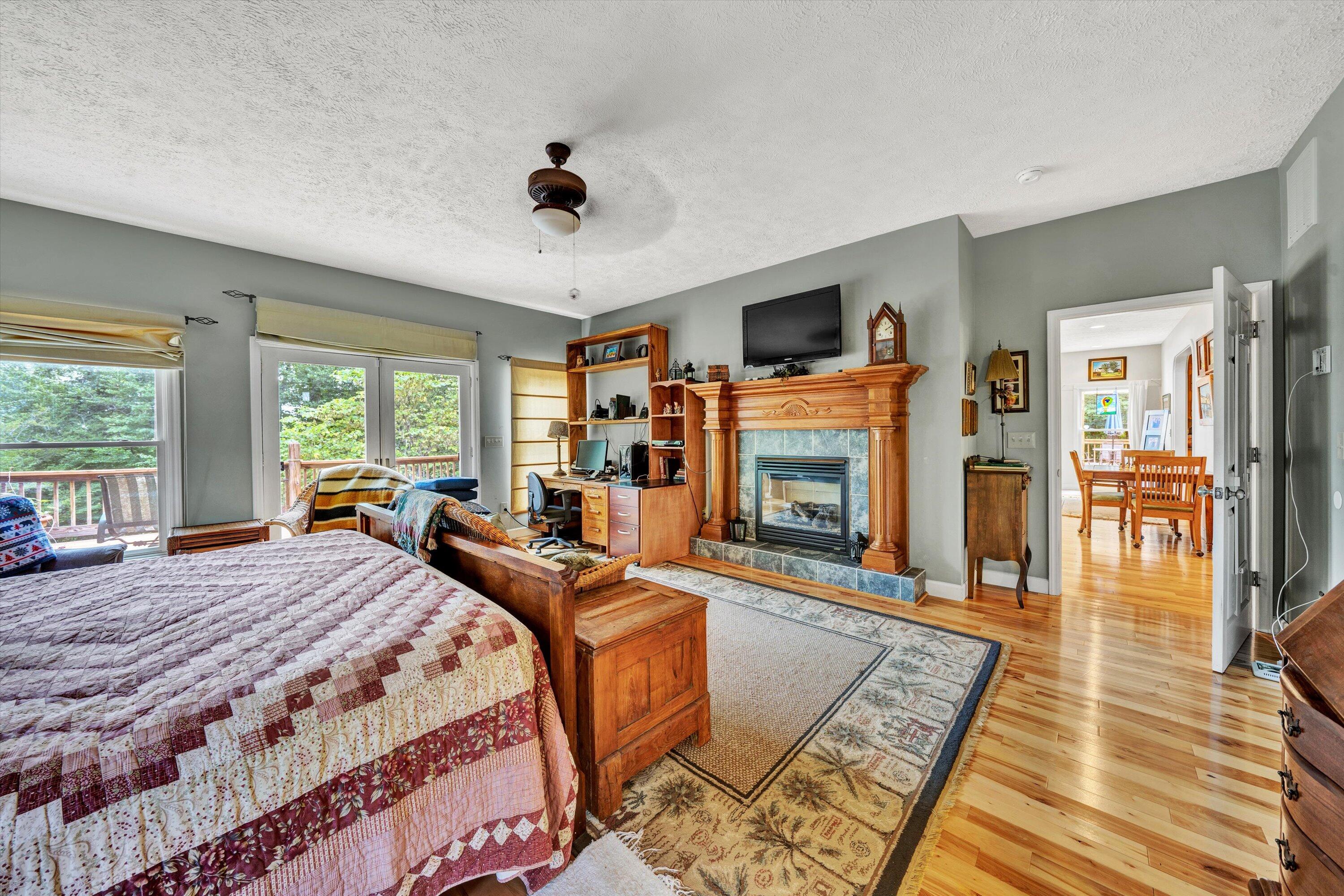 11289 Sontag Road Martinsville, VA 24112 - Photo 31 of 55 a bedroom with a bed a flat screen tv and a fireplace