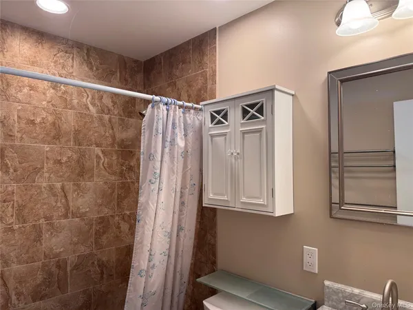 a bathroom with a shower and a mirror