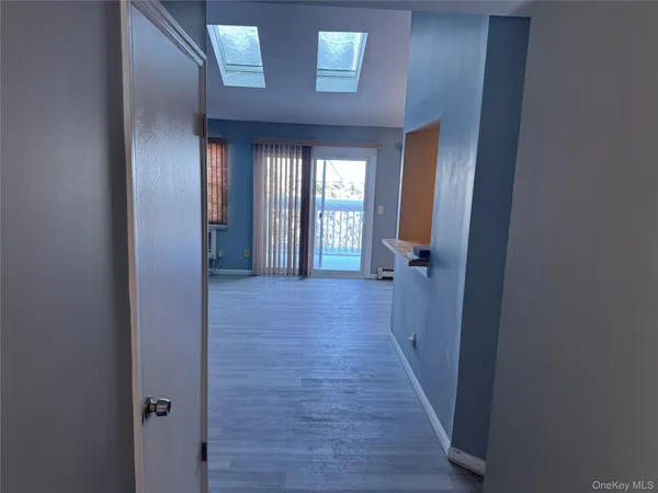 a view of a hallway with wooden floor and closet
