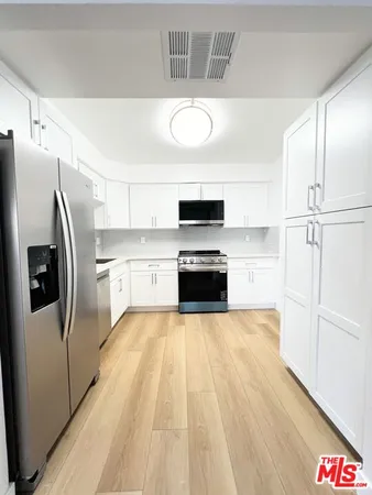 a kitchen with stainless steel appliances a refrigerator and a stove