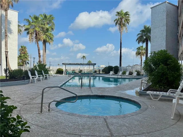 a large building with a swimming pool and sitting area