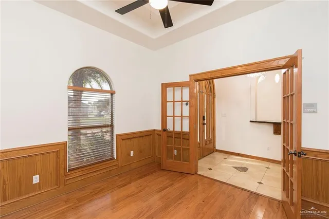 a view of an empty room with a window and wooden floor