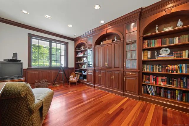 a living room with furniture a rug and a book shelf