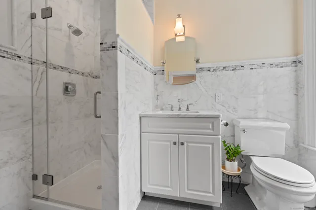 a bathroom with a granite countertop toilet sink and mirror
