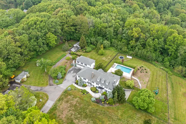 an aerial view of a house with a yard and greenery