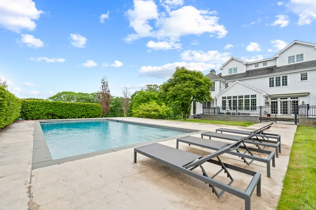 a swimming pool with outdoor seating and yard