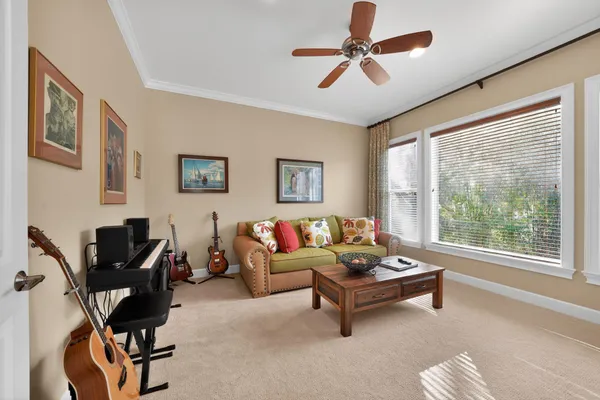 a living room with furniture a ceiling fan and a window