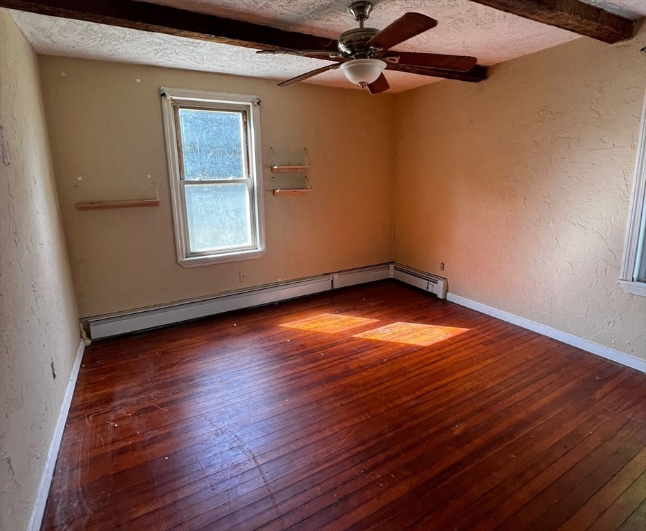 16 Grist Mill Road Grafton, MA 01519 - Photo 7 of 16 an empty room with wooden floor fan and windows