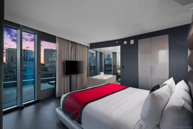 a bedroom with a large bed and a flat tv screen