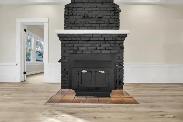 an empty room with wooden floor ceiling fan and windows