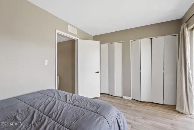 a view of a bedroom with wooden floor