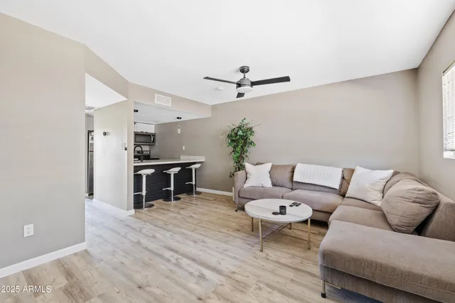 a living room with furniture and kitchen view