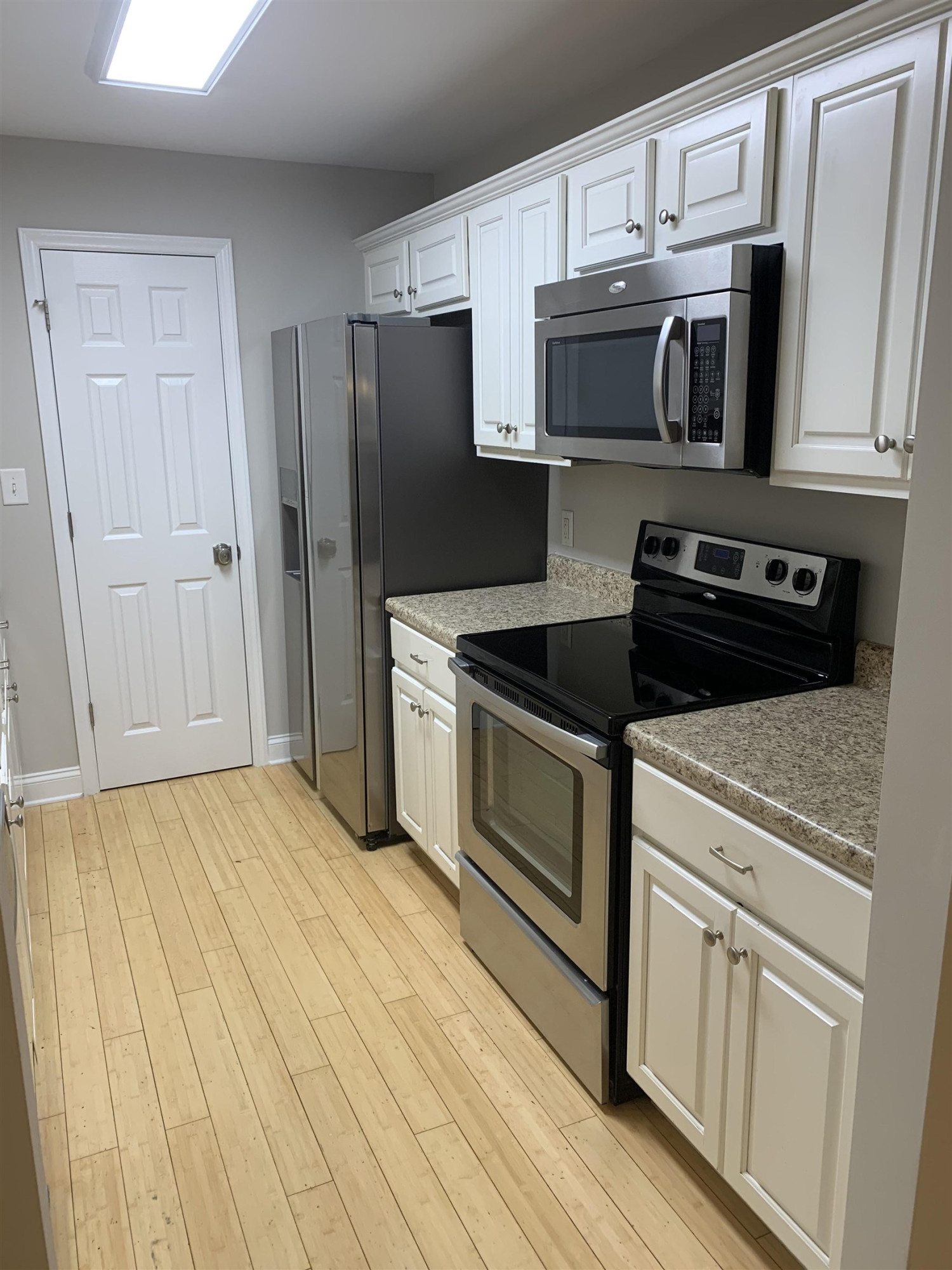 4505 Edwards Mill Road, Unit E Raleigh, NC 27612 - Photo 5 of 14 a kitchen with stainless steel appliances granite countertop a refrigerator stove and microwave