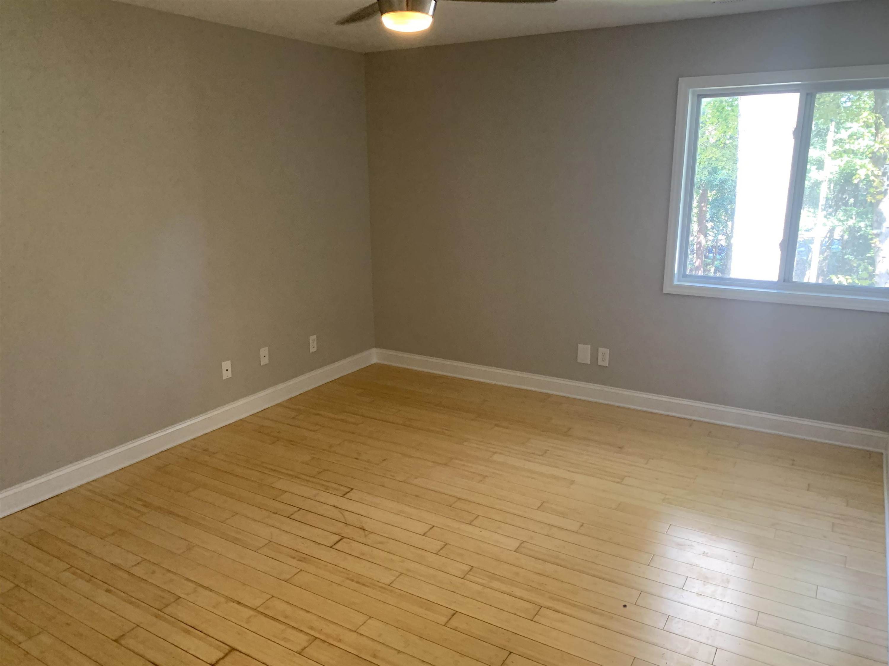 4505 Edwards Mill Road, Unit E Raleigh, NC 27612 - Photo 9 of 14 an empty room with wooden floor and windows