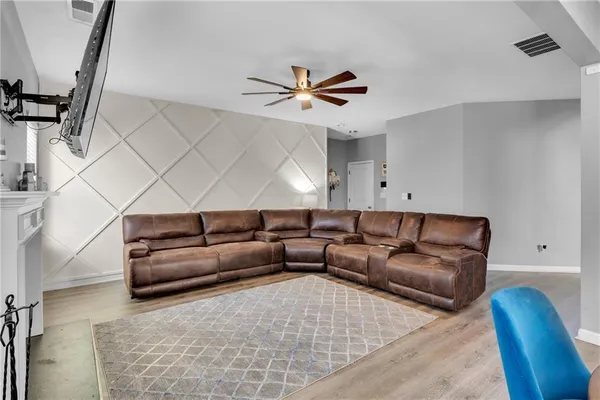 a living room with furniture and a ceiling fan