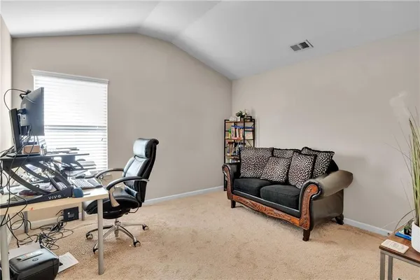 a work room with furniture a flat screen tv and a potted plant