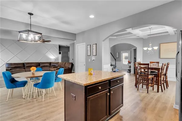 a kitchen with kitchen island stainless steel appliances a dining table and chairs