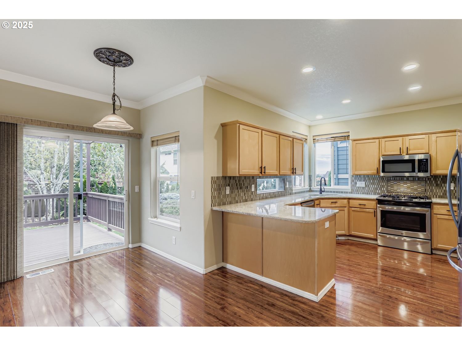 12697 Southwest Canvasback Way Beaverton, OR 97007 - Photo 12 of 41 a open kitchen with granite countertop a stove top oven a sink a counter space and cabinets
