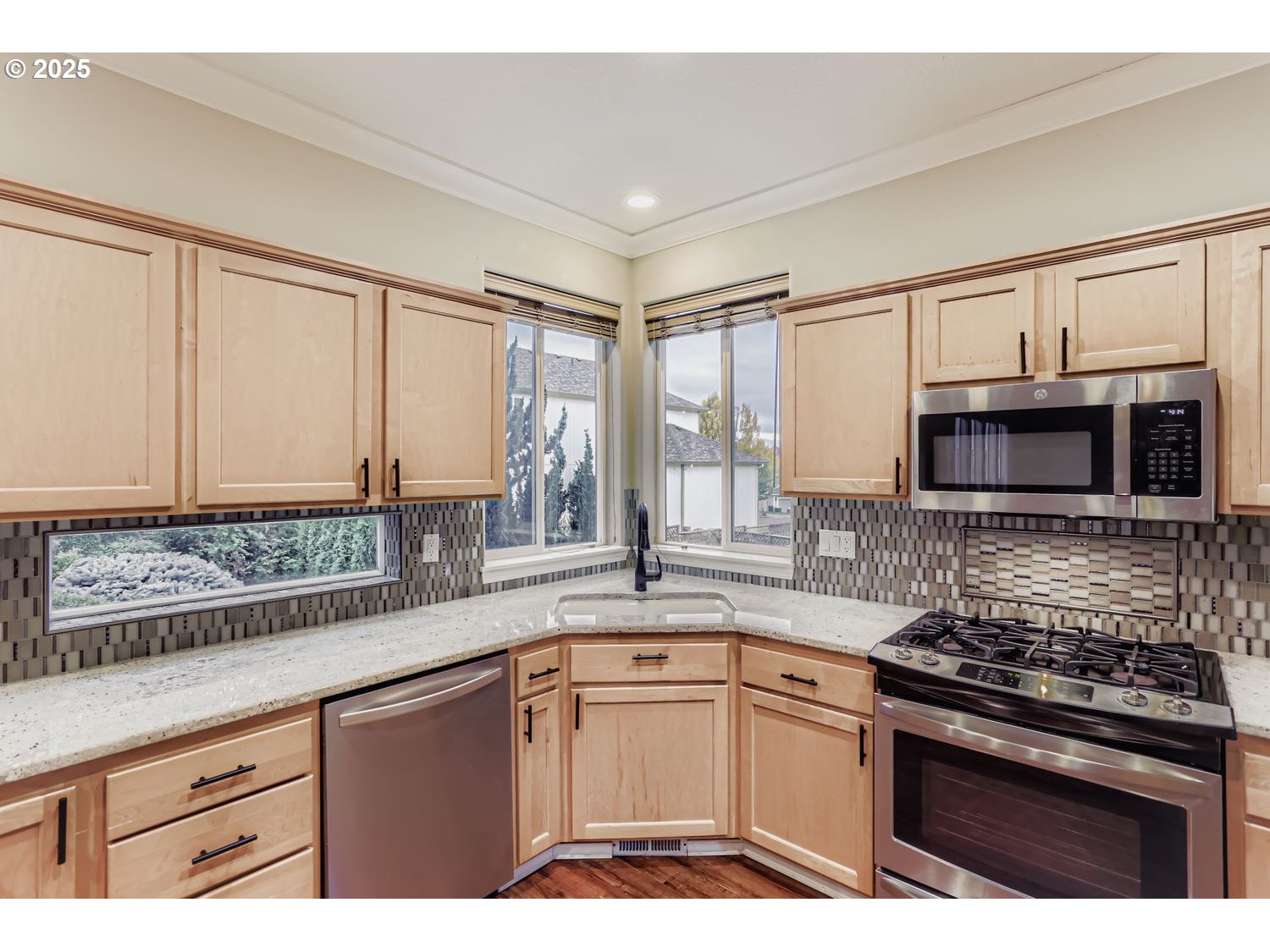 12697 Southwest Canvasback Way Beaverton, OR 97007 - Photo 15 of 41 a kitchen with stainless steel appliances granite countertop a stove a sink and a microwave