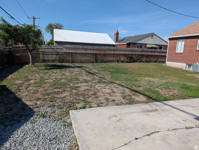 2880 Merton Way Magna, UT 84044 - Photo 25 of 30 Expansive rear yard featuring a concrete patio pad, gravel area, and a wood privacy fence