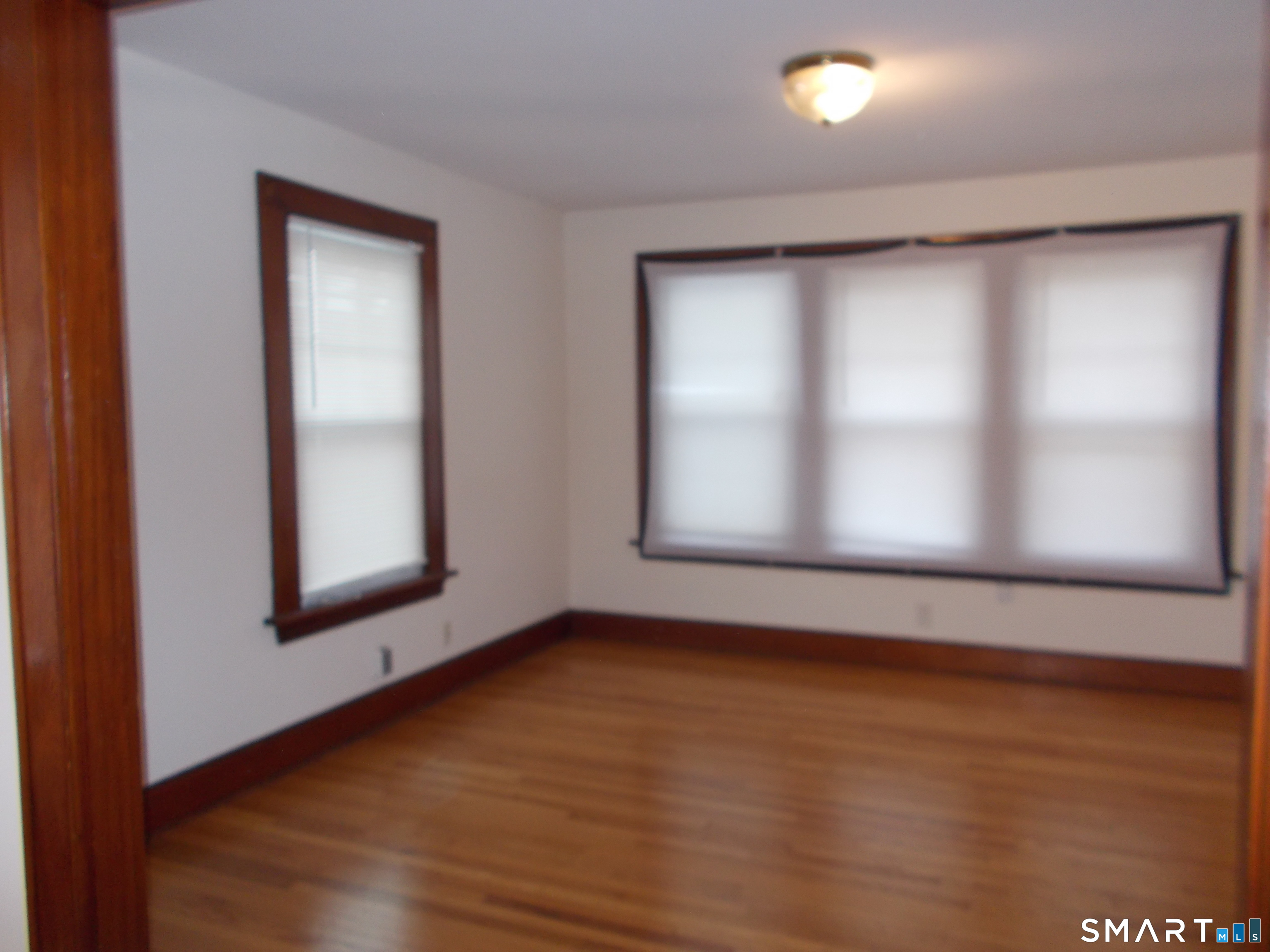 42 Holbrook Place, Unit 2 Ansonia, CT 06401 - Photo 2 of 12 an empty room with wooden floor and windows