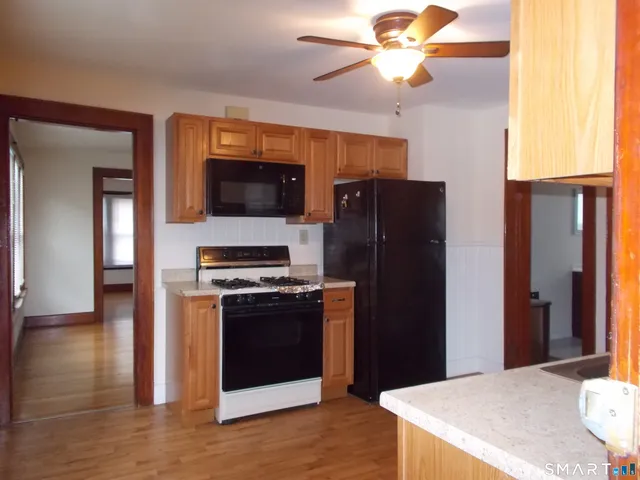 a kitchen with stainless steel appliances granite countertop a refrigerator a stove and a sink