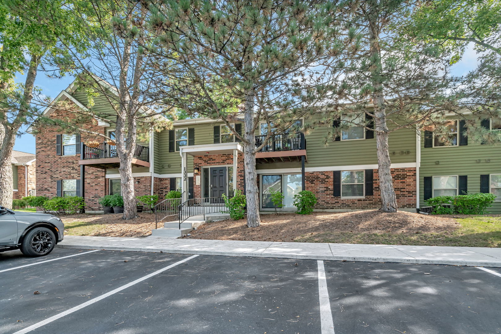 1332 McDowell Road, Unit 104 Naperville, IL 60563 - Photo 2 of 19 a city street lined with buildings and trees