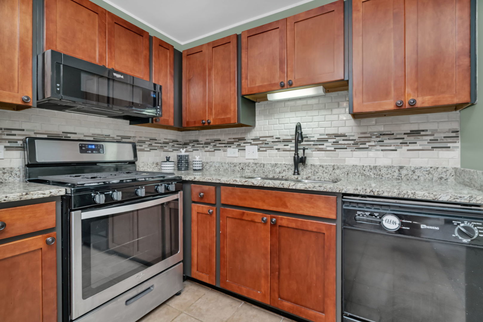 1332 McDowell Road, Unit 104 Naperville, IL 60563 - Photo 10 of 19 a kitchen with granite countertop wood cabinets stainless steel appliances and a sink
