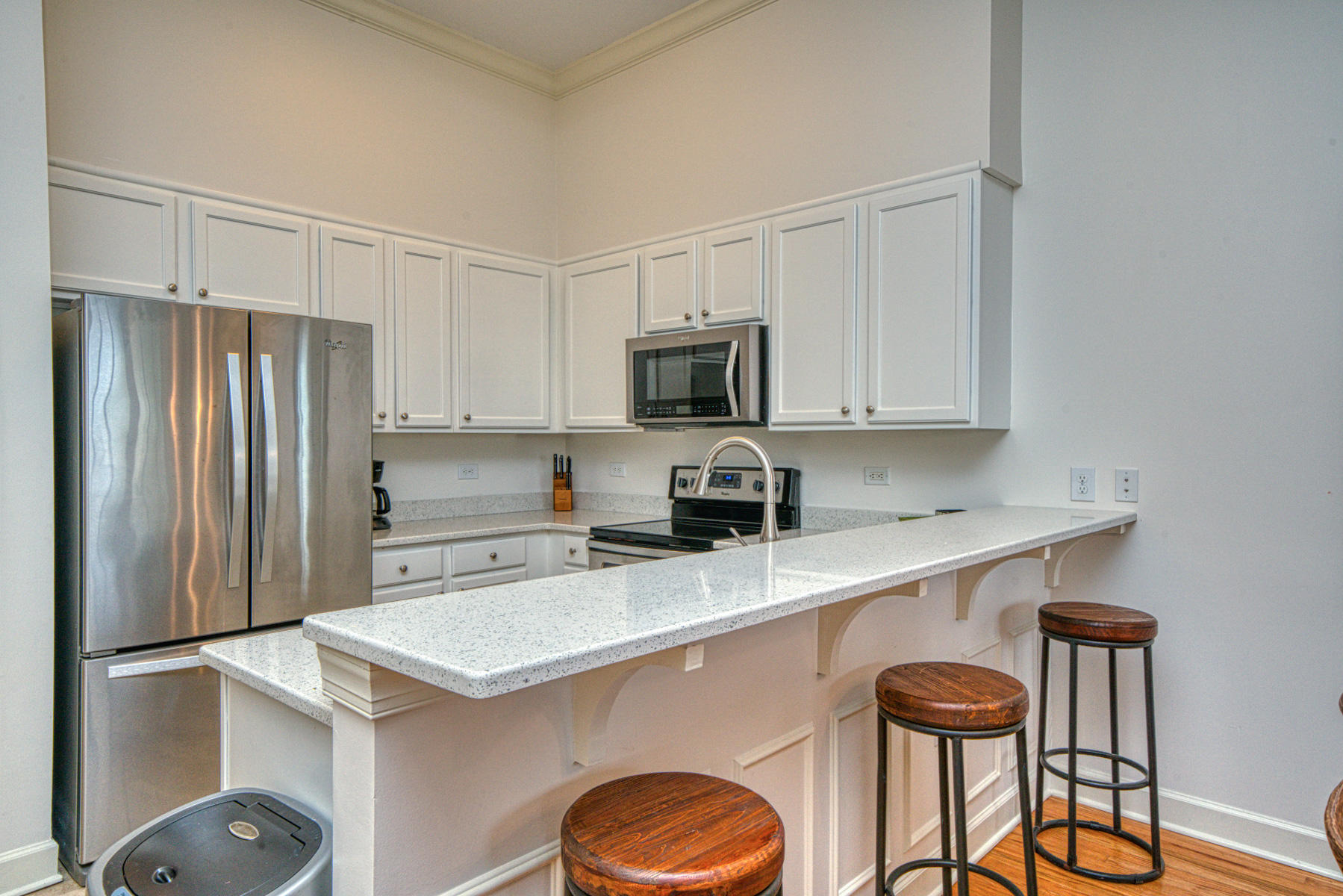 10343 East County Highway 30A, Unit 307 Seacrest, FL 32413 - Photo 10 of 34 a kitchen with a refrigerator a stove a sink and white cabinets with wooden floor